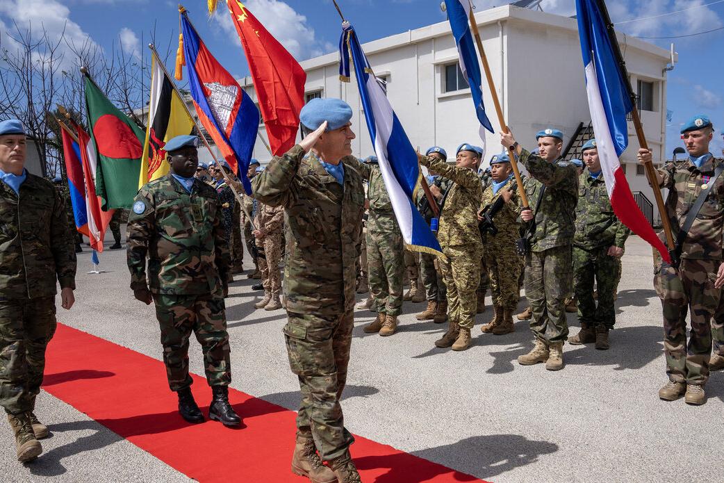 Peacekeepers salute during a procession.